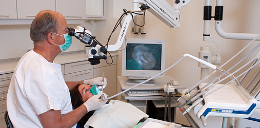 Fagperson ser på pasient i mikroskop 