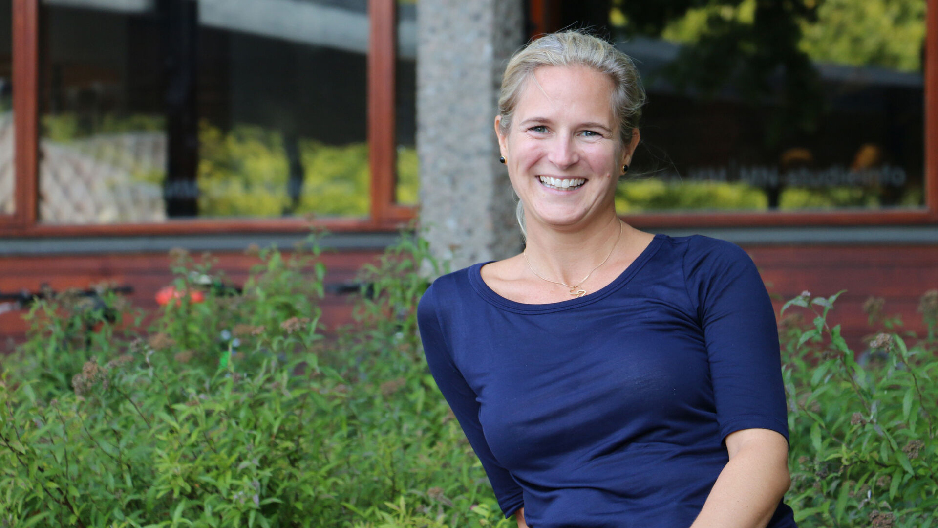 Bilde av ordstyreren Jessica Lönn-Stensrud som sitter smilende på en benk ute