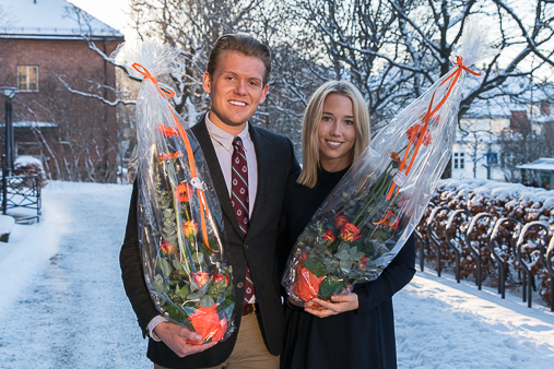 De to kandidatene til Studentforskerprisen oppstilt, smilende, med blomster utendørs. Johnsen står til venstre og Kløv til høyre. Halvnært utsnitt.