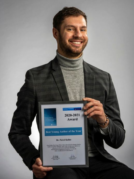 Stipendiat Pawel Kallas viser stolt fram diplomet for utmerkelsen Best young author of the year