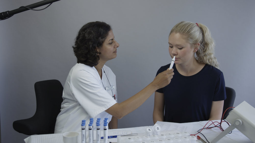 Forsker holder luktepinne under pasientens nese